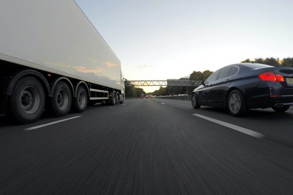Commercial vehicle fleet parts, truck and car on highway.